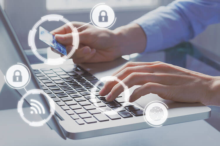 Photo of a person making an online payment with their credit card and laptop. A graphic design of lock icons is superimposed over the photo, symbolizing that the transaction is secure.