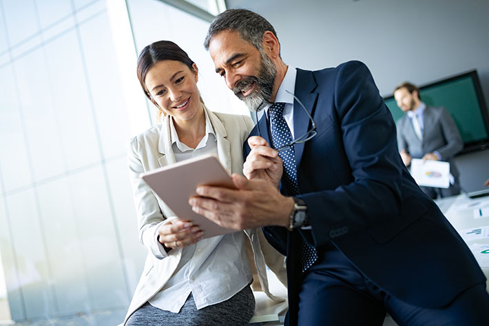 Two members of a political campaign access their campaign data on a tablet through eFund Connect's secure OAuth API